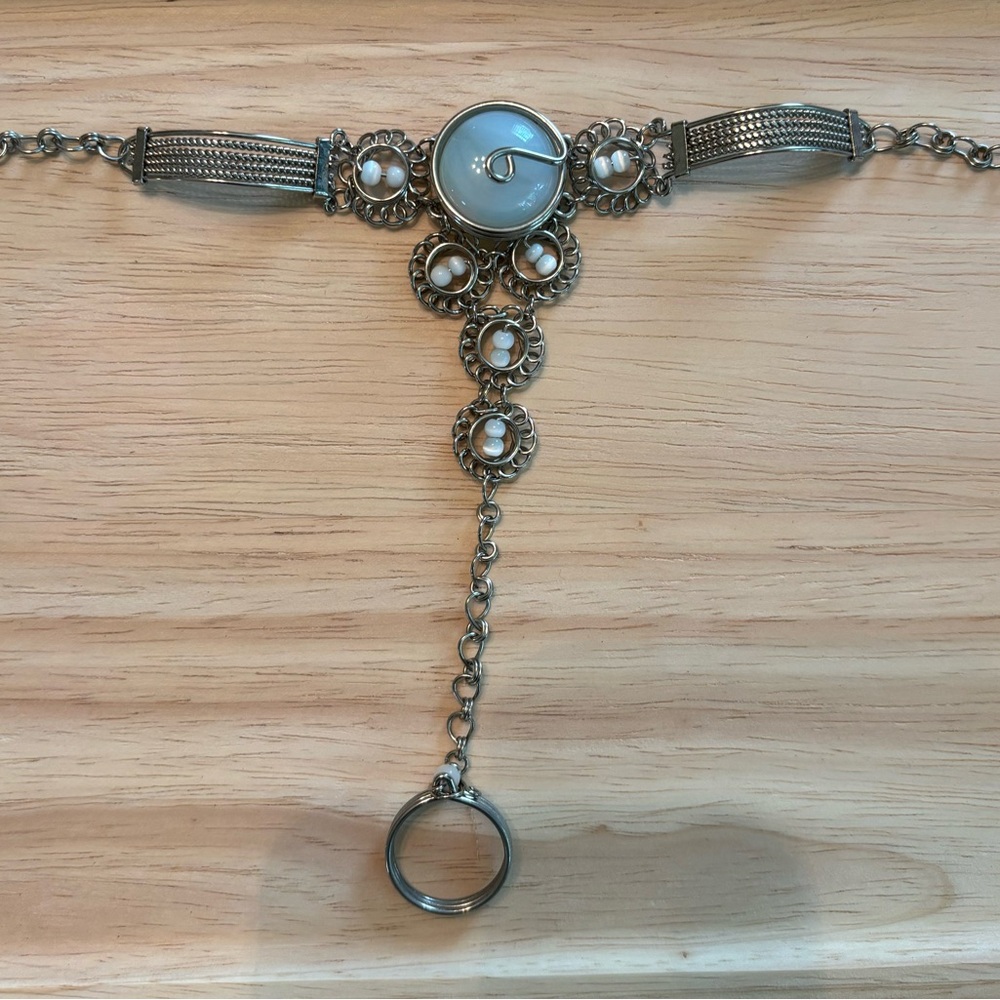 Silver tone bracelet/ring with light blue stone